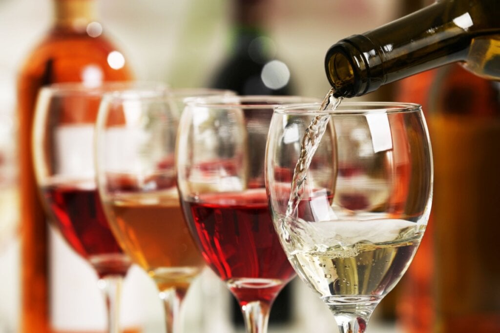 Taças enfileiradas com vinhos em tons diferentes