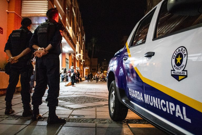 guardas municipais ao lado de viatura