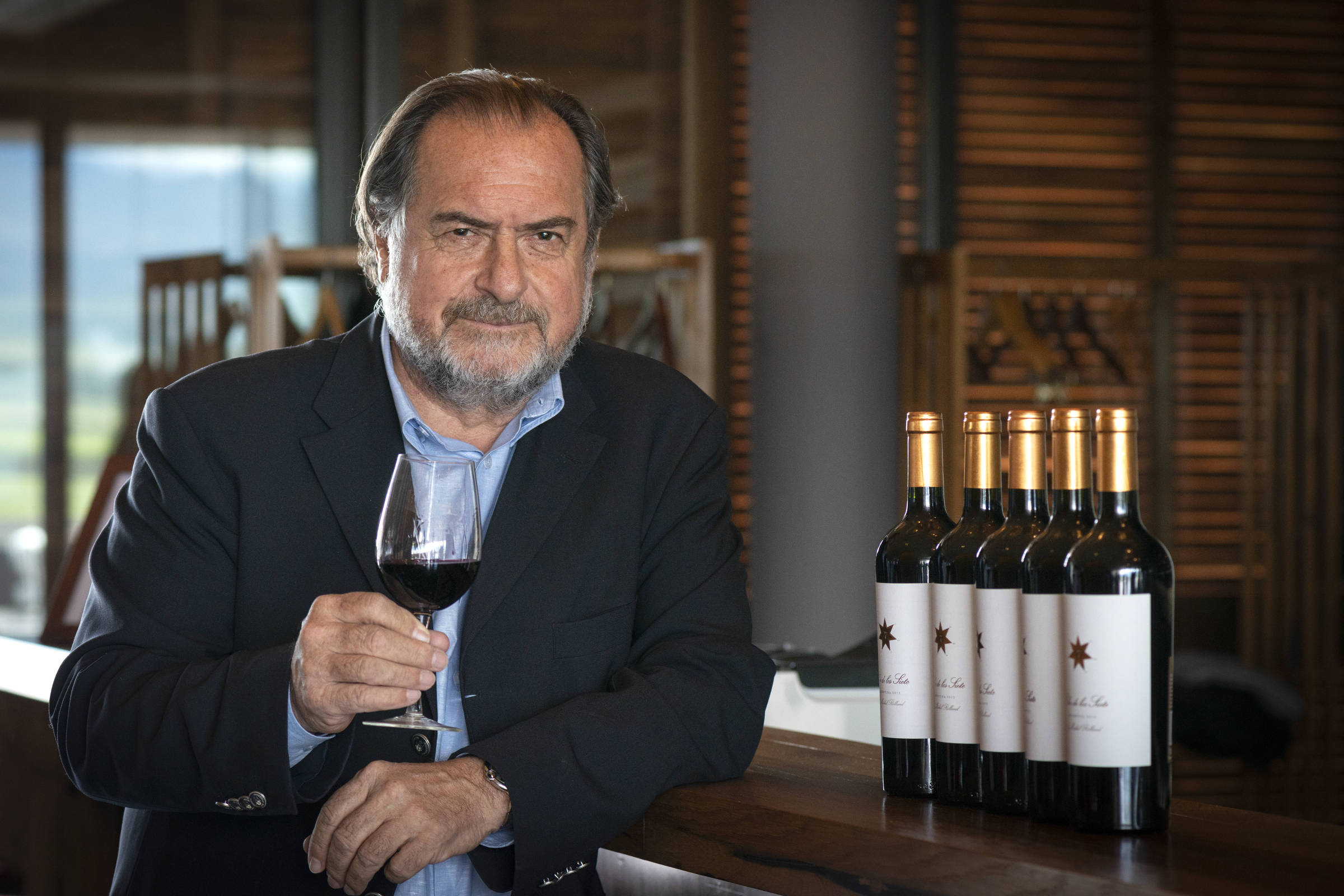 Homem ao lado de garrafas de vinho