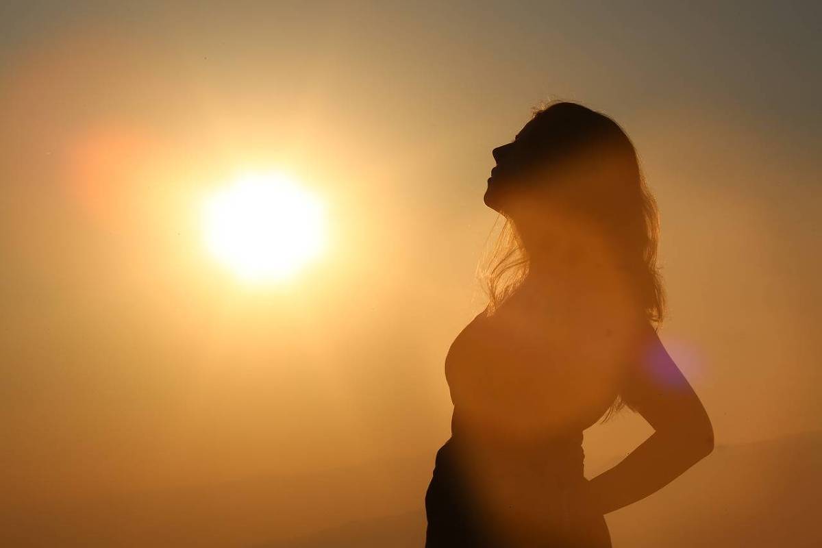 Sombra de uma mulher olhando para o sol