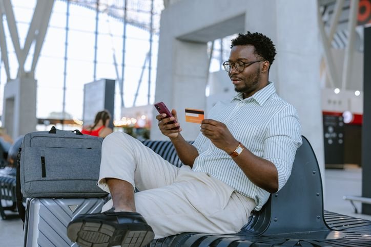 homem-segurando-celular-e-cartao-no-aeroporto