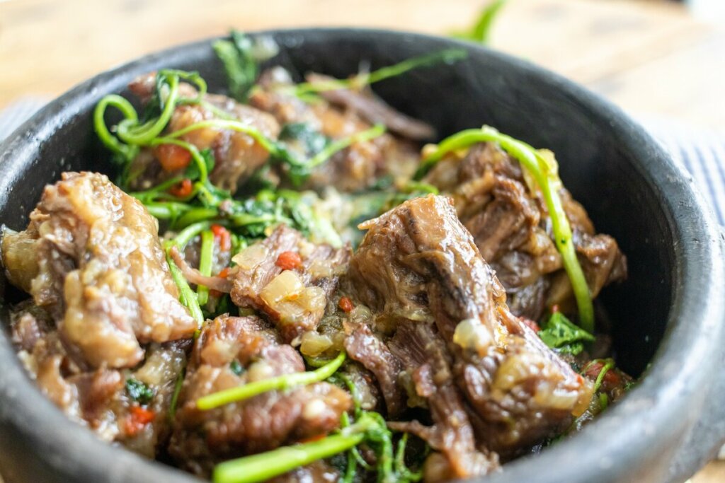 Rabada em uma panela preta com agrião