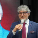 Luciano Menezes, CEO da B2WE Brasil, durante evento empresarial, discursando sobre Reforma Tributária e risco fiscal estratégico.