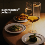 Mesa posta com pratos gourmet e drinks em ambiente intimista representando o jantar exclusivo do evento Protagonistas do Brasil.