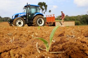 Produtor rural plantando com trator