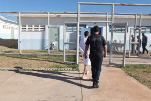 Agente socioeducativo conduz adolescente em conflito com a lei em Unidade de Internação Socioeducativa no Distrito Federal