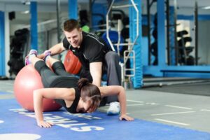 Personal ajuda uma mulher a treinar uma academia