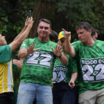 Cinco pessoas vestem camisetas verdes com a inscrição